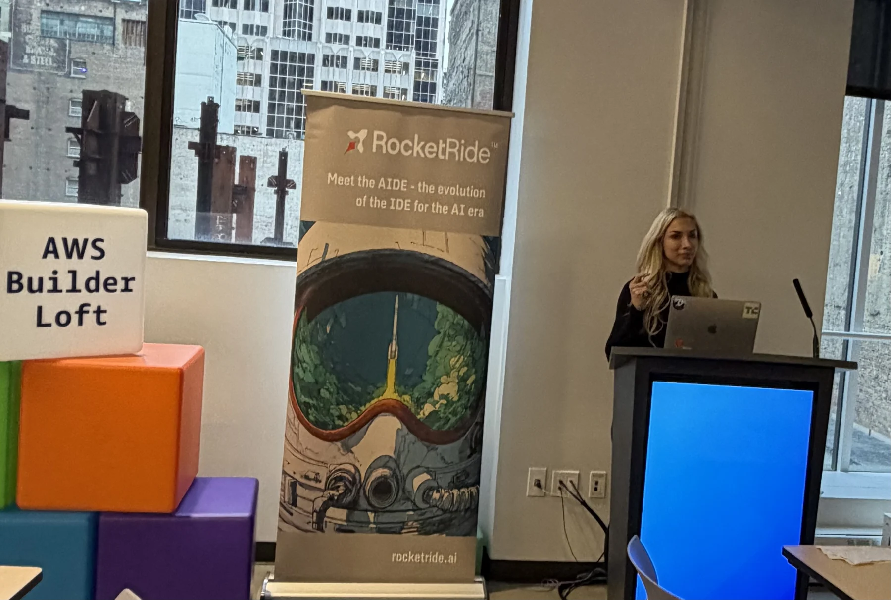 Anya Ozmen at a podium beside AWS Builder Loft and RocketRide signs