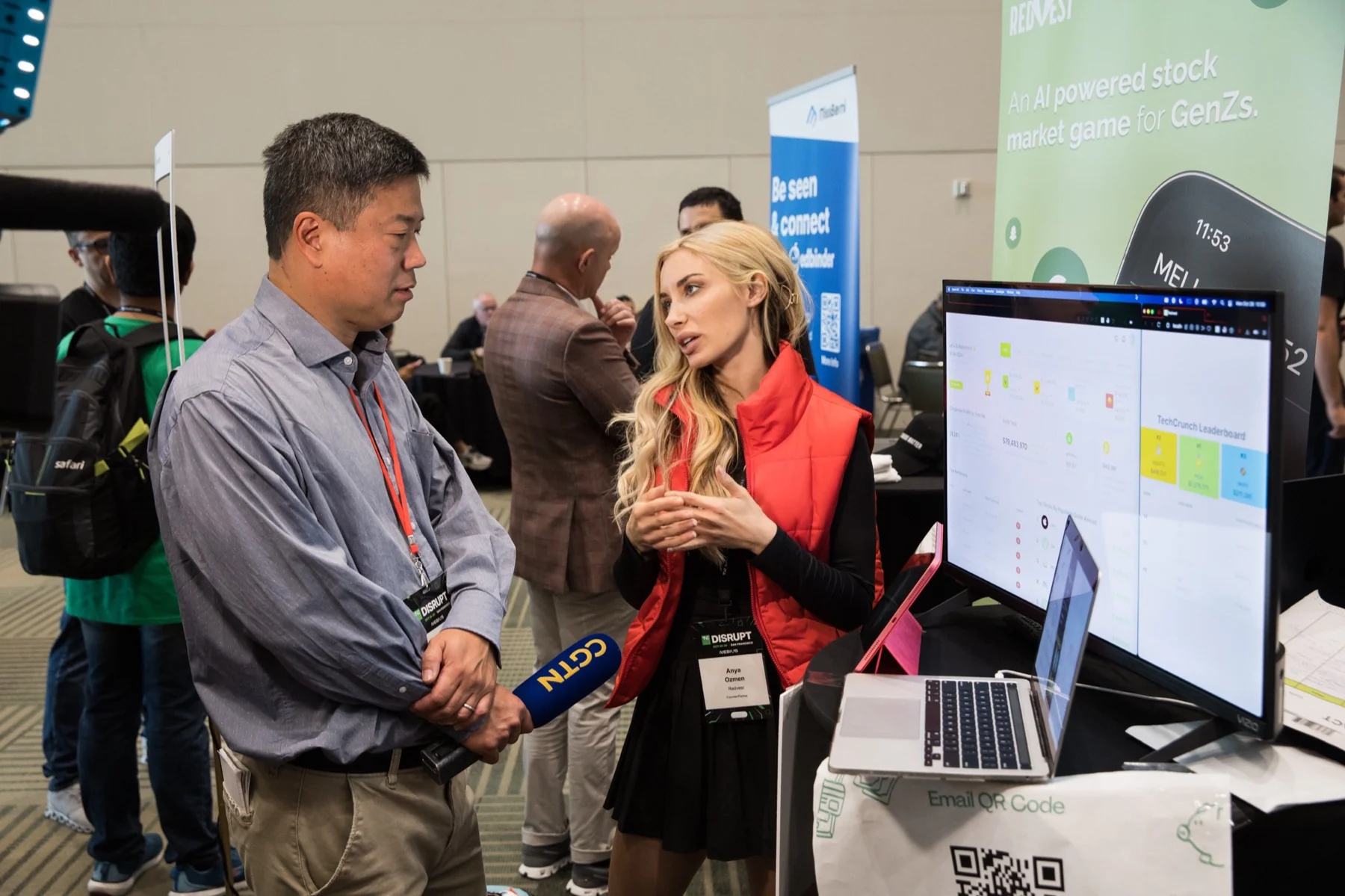 Anya Ozmen discussing Redvest with a reporter at the company’s TechCrunch Disrupt booth