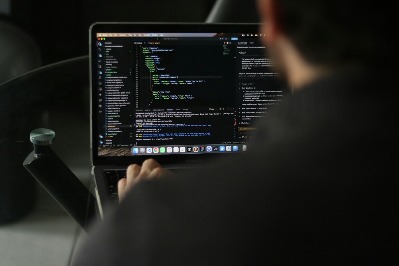 Developer working at a laptop with code on screen